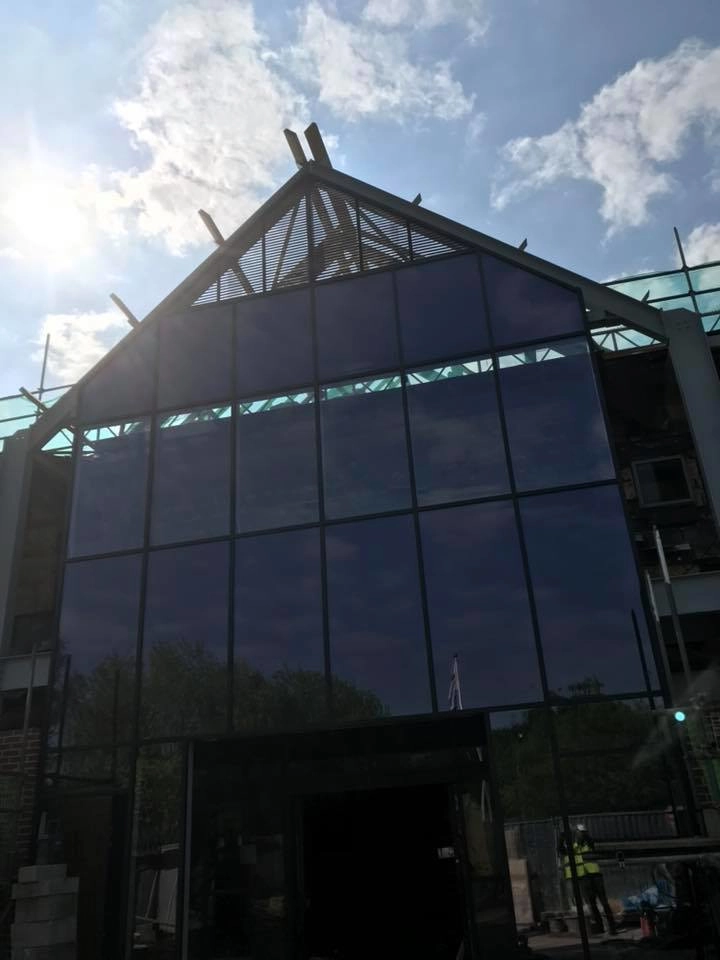 Front view of the building with glass paneling onto the architectural steel A-frame.