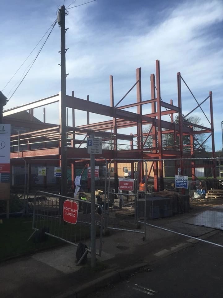 showing the Oakam school construction site in front of the security / safety barriers.